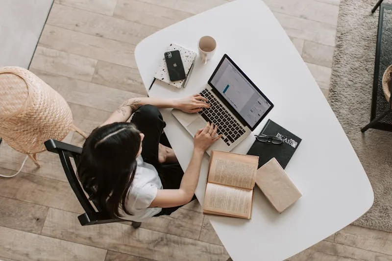 Business owner following up with customers on laptop and phone