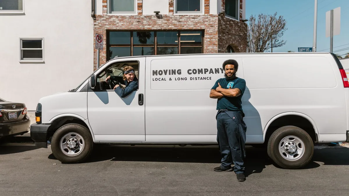 A two-person moving crew with their company van — keeping good crews together through peak season is the real challenge